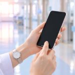 スマホを持つ看護師の手元